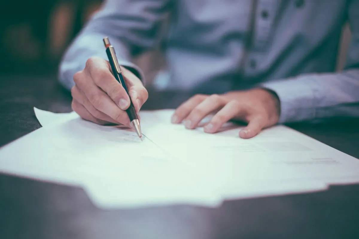 Hands signing a property document